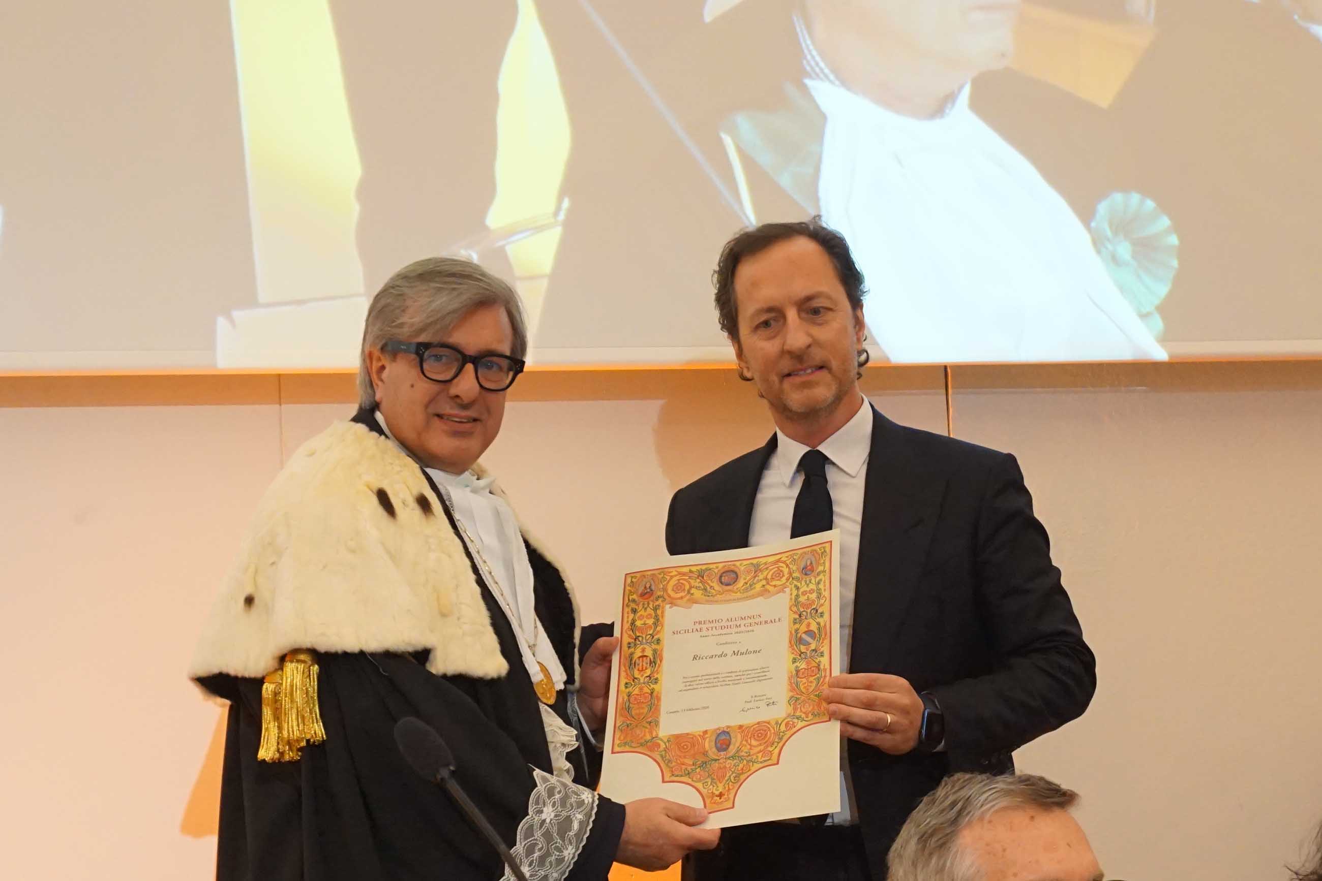 Alessandro Mulone mentre riceve il premio dal rettore Enrico Foti