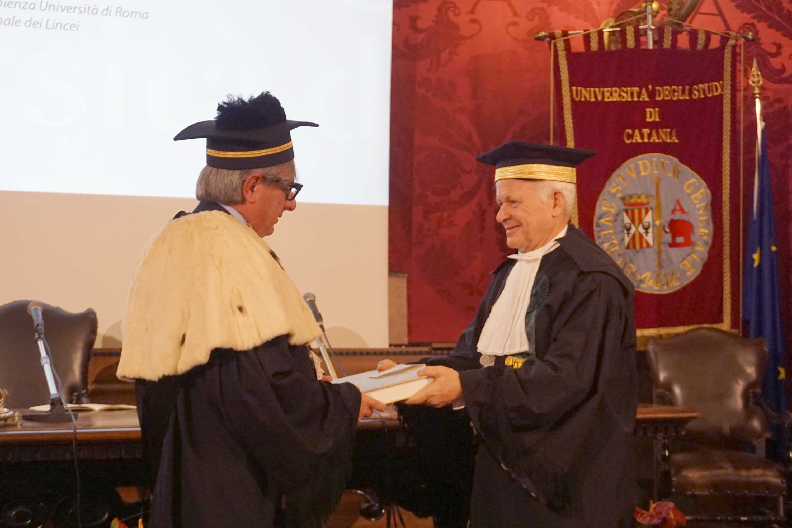 Il rettore Enrico Foti mentre consegna il libro della scienza a Carlo Doglioni