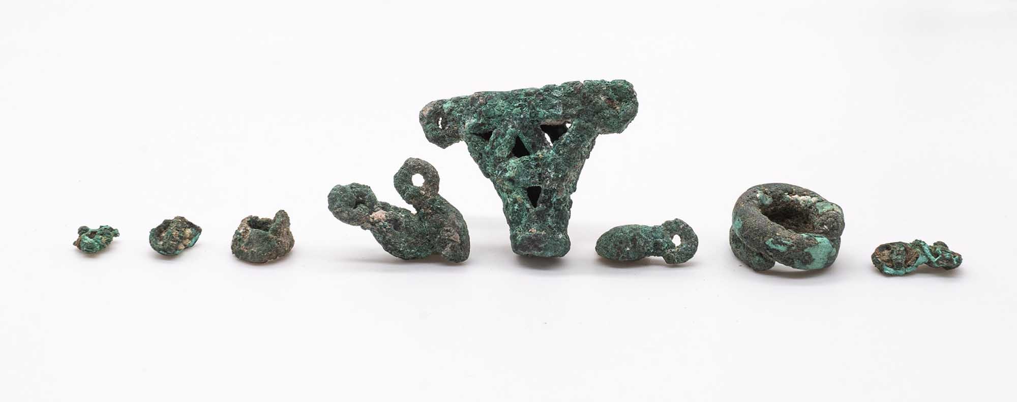 Set di oggetti in bronzo, tra cui bottoni, un anello, un pendente e alcuni ciondoli
